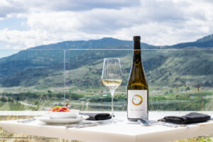 bottle and glass of white wine with dinner plate at Phantom Creek Restaurant