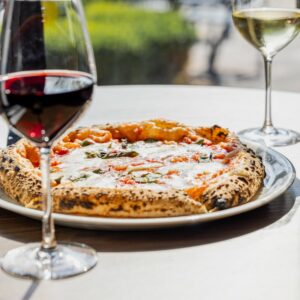 Glass of red wine and artisan pizza at Masiero Pizzeria in Vernon, British Columbia