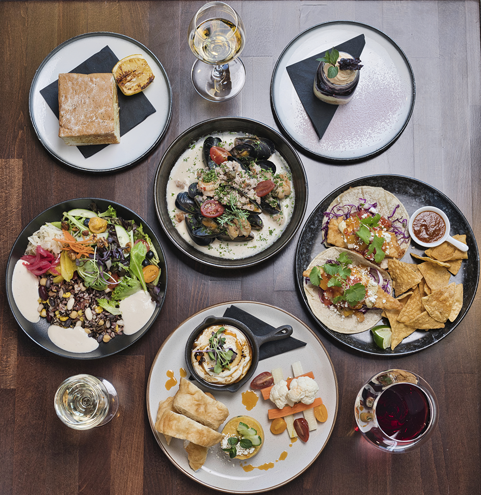 table with various plates of food and wine